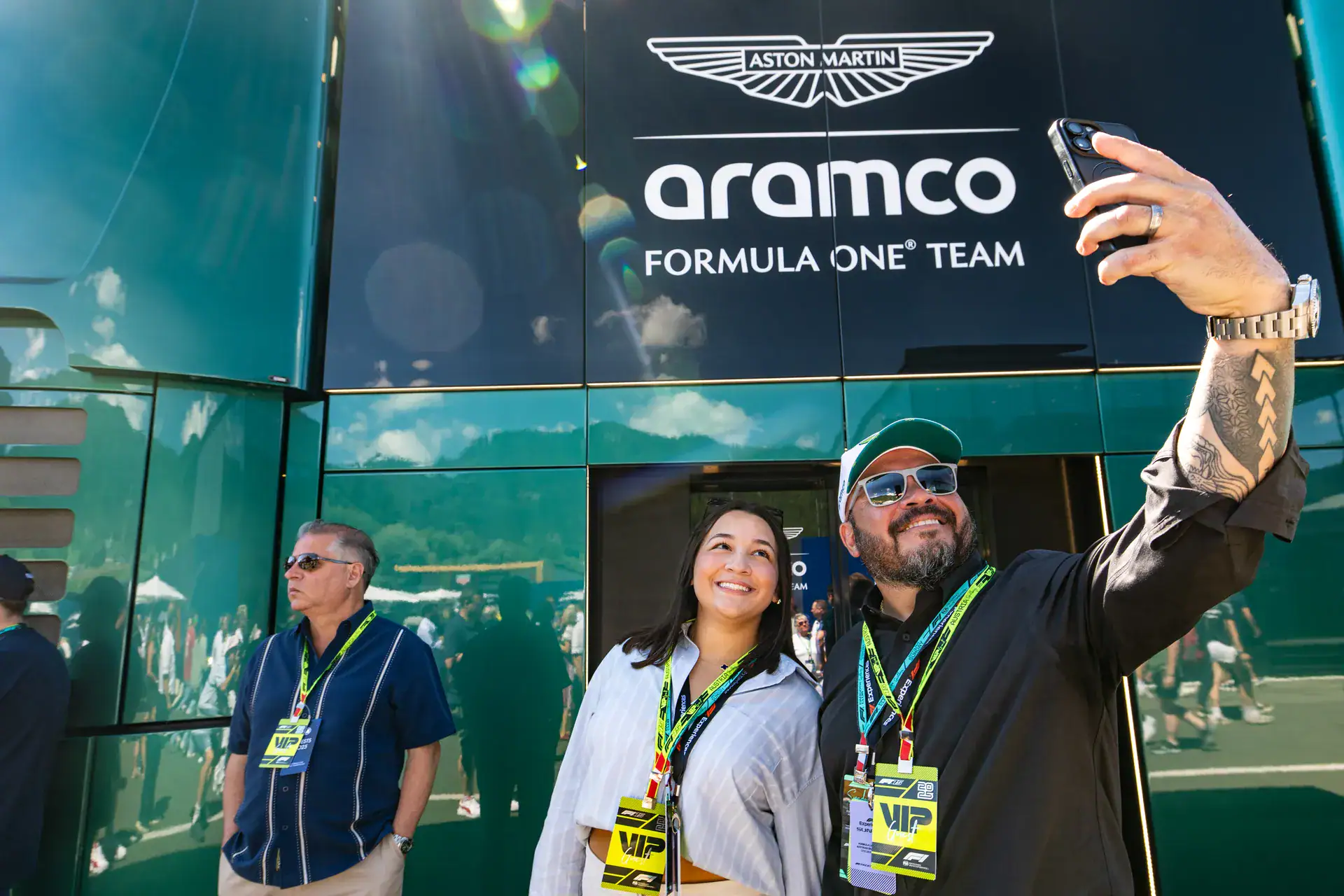Guests taking a selfie in front of the Aston Martin Aramco F1 team motorhome at the Austrian Grand Prix