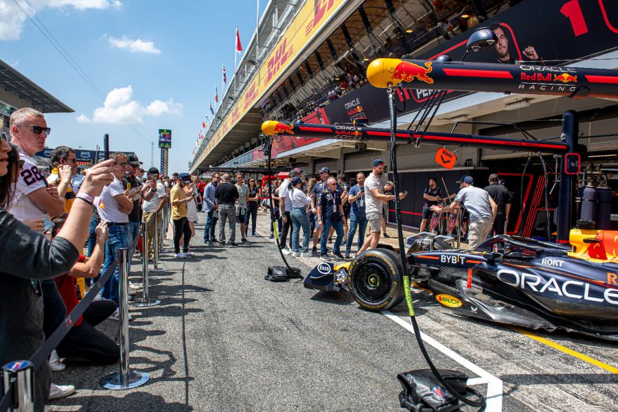 Guests in the pit lane next to a Red Bull Racing F1 car at the Spanish Grand Prix